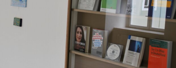 Das Bild zeigt die Vitrine vor dem Aufgang zur Bibliothek des Studienortes Fürstenfeldbruck, hier als Veranschaulichung für den Zugang zu weiterer Polizeiliteratur.